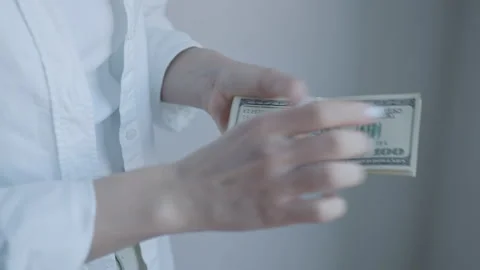 Close-up Image of Hands Counting US Hundred Dollar Bills, Highlighting Wealth Stock Footage 274894277