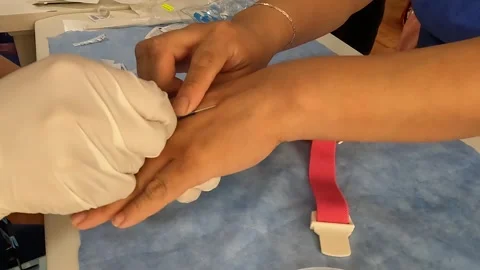 Close up image of hands with latex gloves canalizing a vein with a needle Stock Footage 246944808