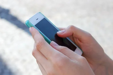 Close-up image of hands using smartphone on city shopping street, searching or Stock Photos