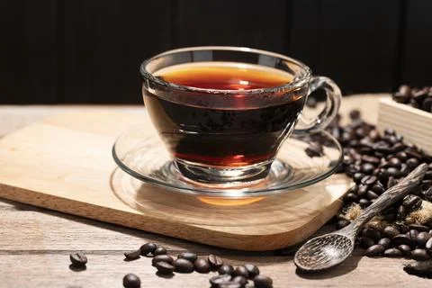 A close-up image of a hot coffee cup on a table, bathed in morning light. A.. Stock Photos