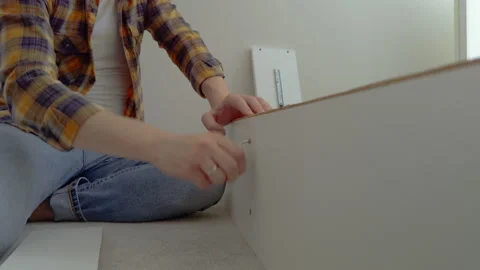 Close-up image of how a man assembles quality white furniture at home by himself Stock Footage 281978025