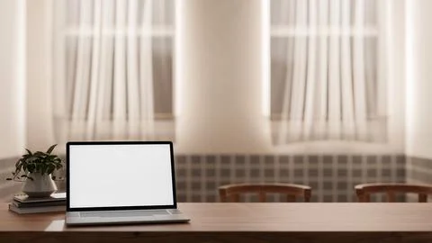 A close-up image of a laptop white screen mockup on a wooden table in a coz.. Illustrazione stock