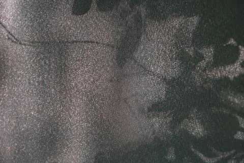 Close-up image of leaf-patterned fabric with contrasting dark leaves scattere Stock Photos