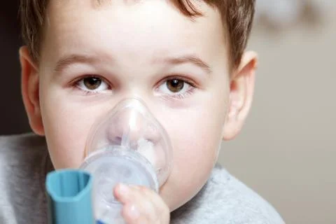 Close-up image little boy using inhaler for asthma. Stock Photos