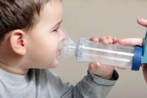 Close-up image little boy using inhaler for asthma. Stock Photos