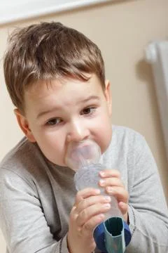 Close-up image little boy using inhaler for asthma. Stock Photos