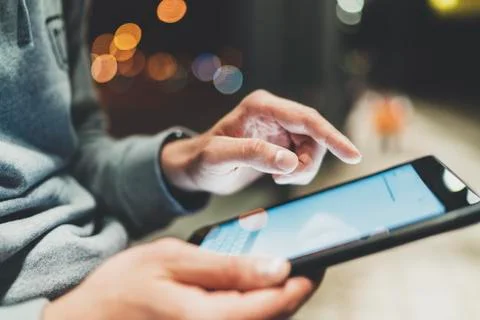 Close-up image of male hands using modern digital tablet at night Stock Photos