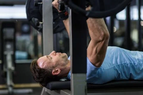 Close up image of man doing bench press at the gym. Stock Photos