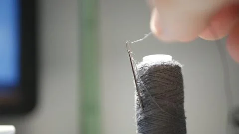 Close Up Image with Man Hand Introducing Thread in Needle Hole Foto stock