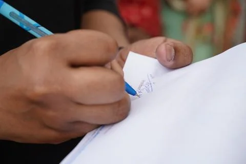 Close up image of a man signing a document with selective focus on pen tip Stock Photos