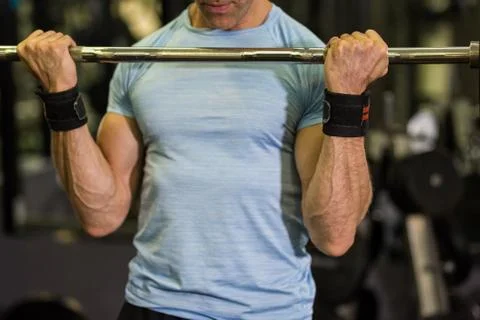 Close up image of man using barbell at the gym. Stock Photos