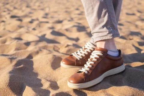 Close up image of man walking alone sandy beach with blue ocean and white san Foto stock