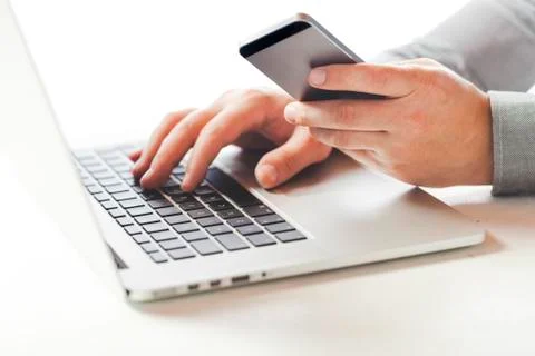 Close up image of multitasking business man using  a laptop and mobile phone Foto stock