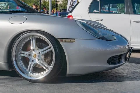 Close-up image of a parked silver Porsche sports car, contrasting black wheel Stock Photos