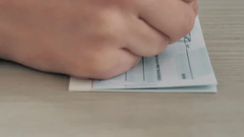 Close-up image of a person's hand filling out a bank check for 1000 euros. Stock Footage 234429470