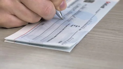 Close-up image of a person's hand filling out a bank check for 1000 euros. Stock Footage 236586514