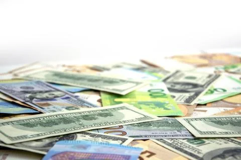 A close up image of a pile of US dollar and euro banknotes scattered on a whi Stock Photos