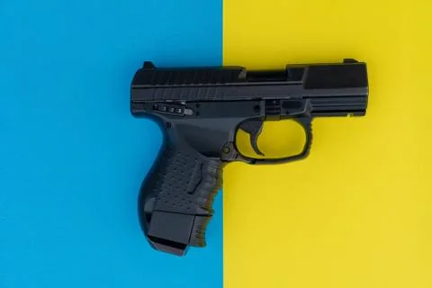 Close up image of pistol on a multicolored background . Black gun on a fun ye Fotos Stock