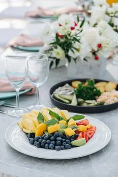 Close up image of a plate with sliced fruit and berries on a banquet table Stock Photos