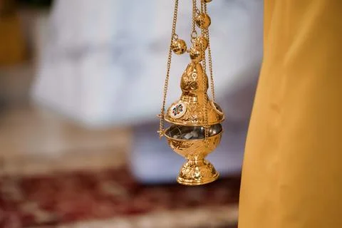 A close-up image portrays a beautifully crafted golden censer actively used d Stock Photos