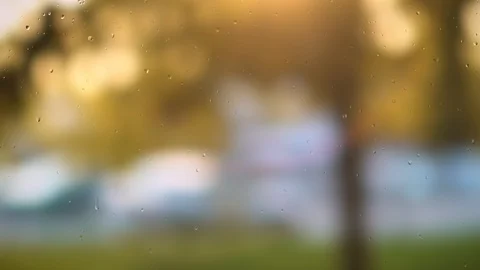 Close up image of rain drops falling on a window . Blurry background Stock Footage 99640730