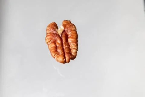 Close-up image of a raw pecan nut on a white background Foto stock