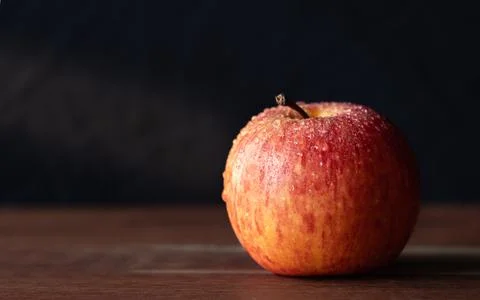 Close-up image of a red Apple with water droplets on dark background Stock Photos