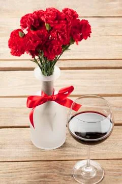 Close up image of red flower and wine decorated on table Stock Photos