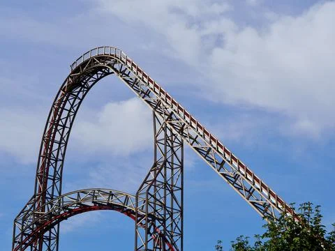 A close-up image of a red rollercoaster track and the blue sky Foto stock