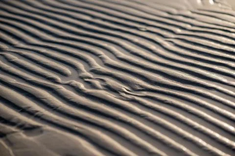 A close up image of a sandy surface with gentle waves Stock Photos