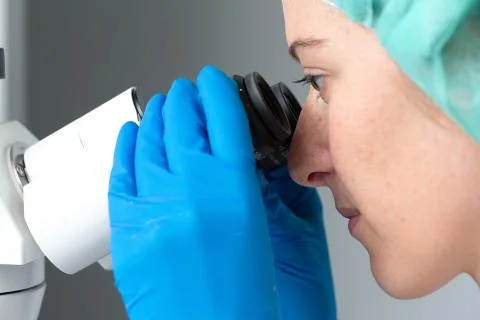 Close image of scientific researcher at microscope Fotos de archivo
