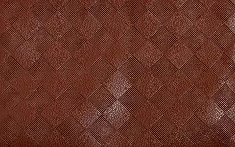 Close-up image showcasing brown leather with a detailed and intricate diamond pa Stock Photos