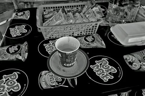 A close-up image shows a coffee cup on a Pop Mie tablecloth Stockfoto's