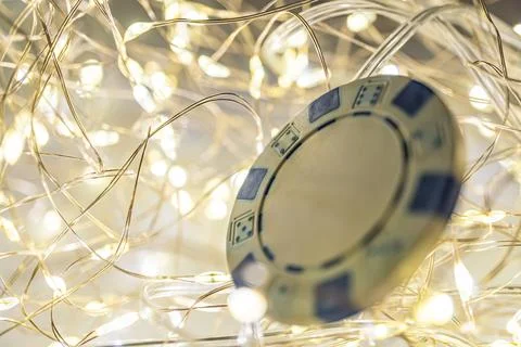 Close-up image of a single playing card under festive string lights, sugges.. Photos