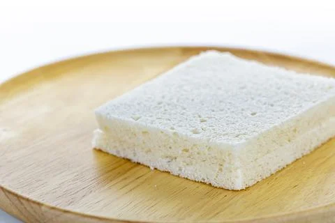 Close-up image of a square slice of white bread on a wooden plate showing s.. Foto stock