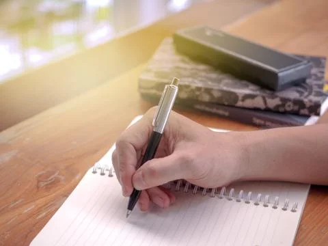 Close up image of student writing on a coffee mug on a coffee table Stock-Fotos