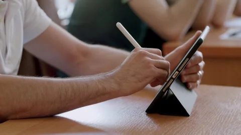 Close-up image of a student writing down the information taught by the teacher Stock Footage 246882255