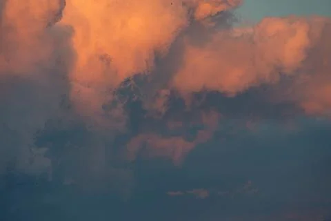 Close-up image of a sunset sky filled with cumulus clouds, displaying hues of 写真素材