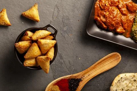 Close up image of a table with delicious dishes from India. Low light dark ba Stock Photos