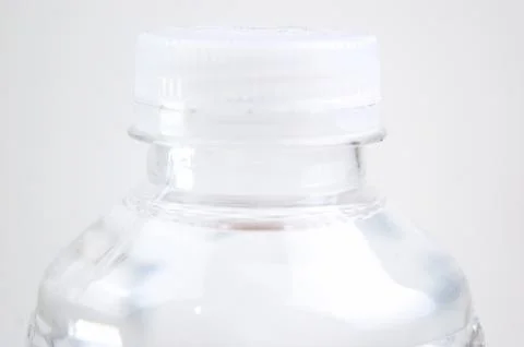 Close-up image of the top of a plastic bottle filled with water and its lid.. Stock Photos