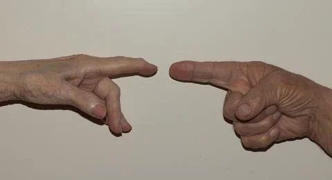 Close-up image of two elderly hands, with fingers extended, pointing toward.. Foto stock