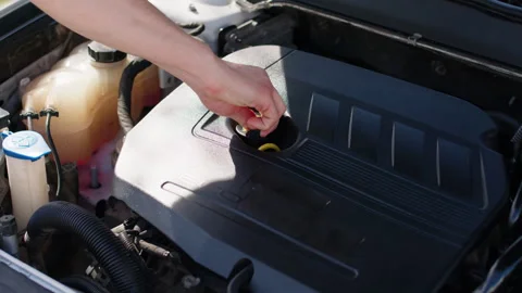 Close-up image under the hood of a car, a man's hand opens the lid where the oil Stock Footage 280029986