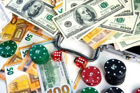 A close-up image of various poker chips, dice, and US dollar bills and Euro b Stock Photos