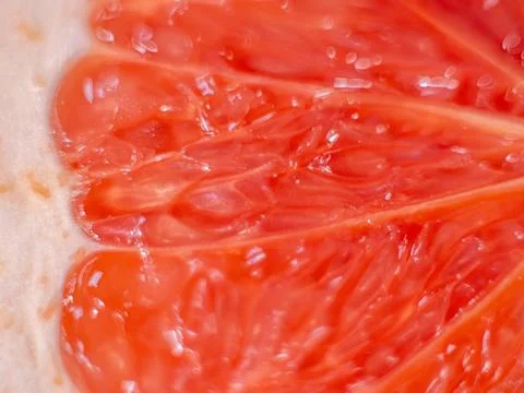 Close-up image of a vibrant grapefruit slice showing detailed pulp and segments. Stock Photos