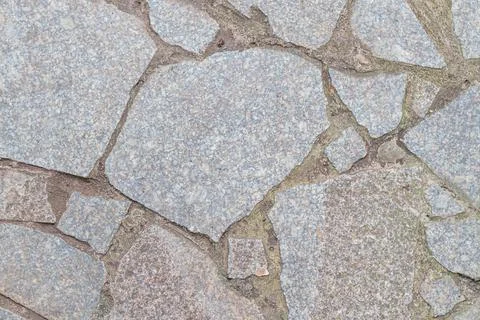 Close-up image of weathered, irregular stone surface with cracks and a ligh.. Stock Photos