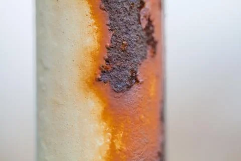 Close-up image of white colored old sheet of metal is covered by deep rust Stock Photos