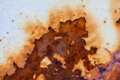 Close-up image of white colored old sheet of metal is covered by deep rust Stock Photos