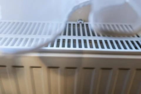 Close-up image of a white radiator situated in a room. This heating element is Stock Photos