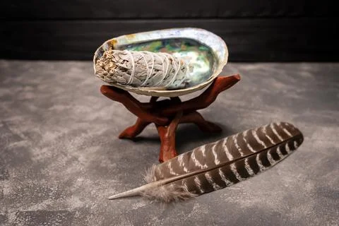 A close up image of a white sage bundle in an abalone shell. Foto stock