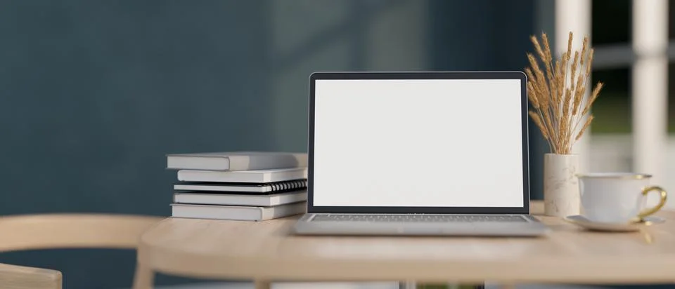 Close-up image of a white-screen laptop computer, books, and a coffee cup o.. Illustrazione stock
